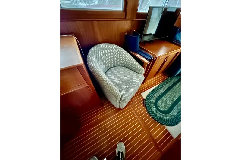 Slide: The Image of Cozy interior of 1999 Grand Banks 46 Europa yacht with chair and wooden cabinetry. - 13