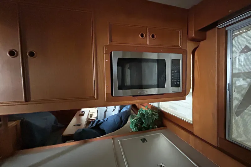Slide: The Image of Interior of 1999 Grand Banks 46 Europa with microwave and wooden cabinetry. - 14
