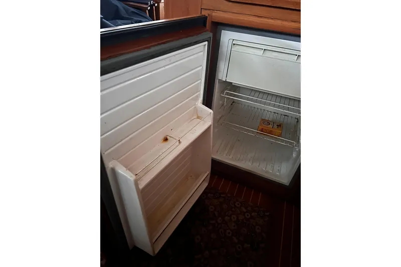 Slide: The Image of Open refrigerator on 1999 Grand Banks 46 Europa yacht, showing interior shelves and baking soda box. - 19