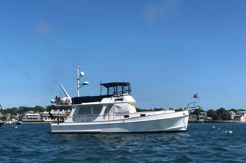 Slide: The Image of 1999 Grand Banks 46 Europa yacht anchored on calm water under clear blue sky. - 2