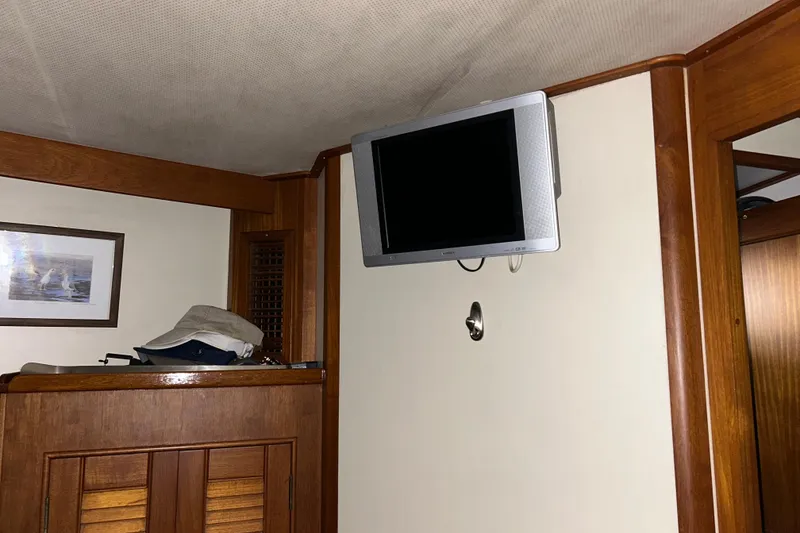 Slide: The Image of Interior of 1999 Grand Banks 46 Europa yacht with mounted TV and wooden cabinetry. - 28
