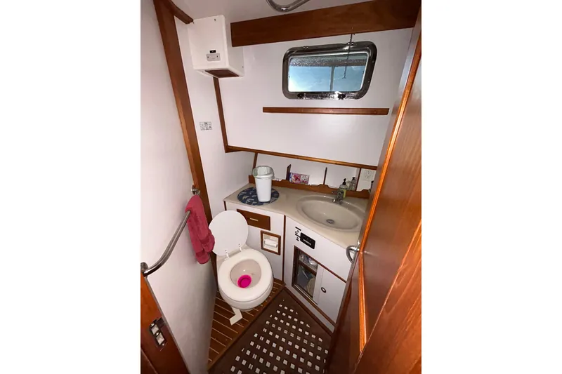 Slide: The Image of Bathroom interior of 1999 Grand Banks 46 Europa yacht with wooden accents and porthole window. - 30