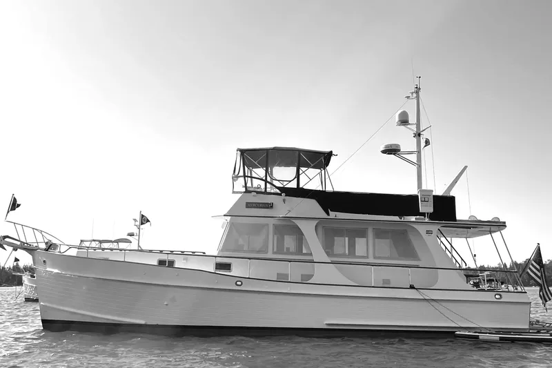 Slide: The Image of 1999 Grand Banks 46 Europa yacht on calm water under clear blue sky. - 4