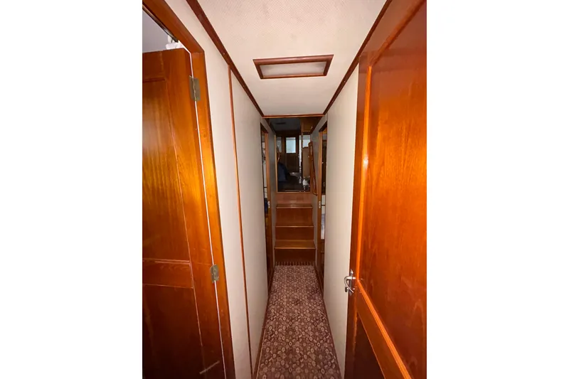 Slide: The Image of Narrow hallway inside 1999 Grand Banks 46 Europa yacht with wooden doors and carpeted floor. - 43