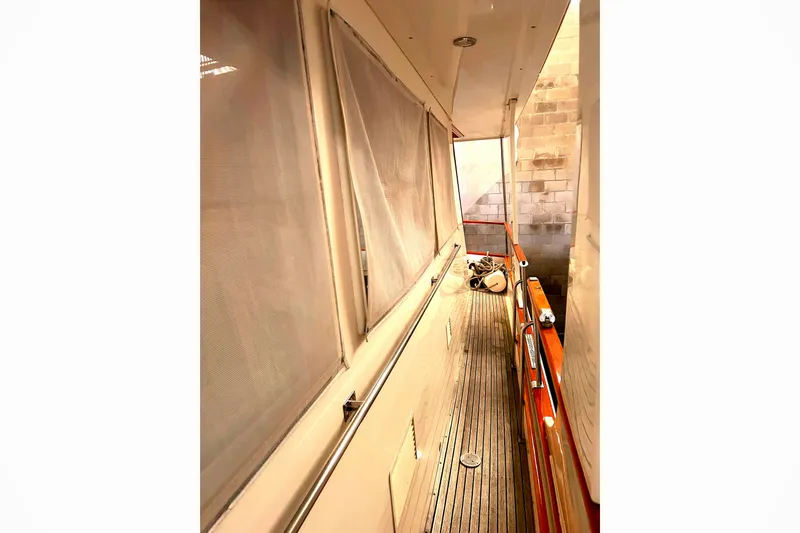 Slide: The Image of Side deck of 1999 Grand Banks 46 Europa yacht with wooden railings and netted windows. - 46