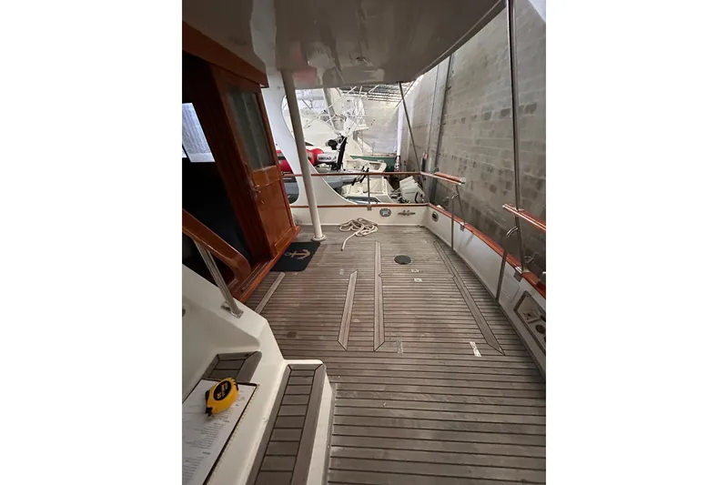 Slide: The Image of 1999 Grand Banks 46 Europa yacht deck with wooden flooring and nautical decor. - 47