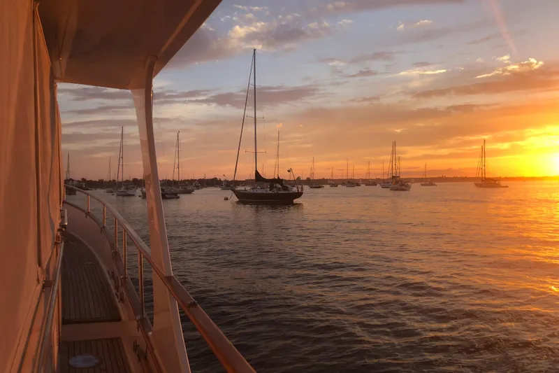 Slide: The Image of Sunset view from a 1999 Grand Banks 46 Europa yacht, overlooking a serene harbor. - 57