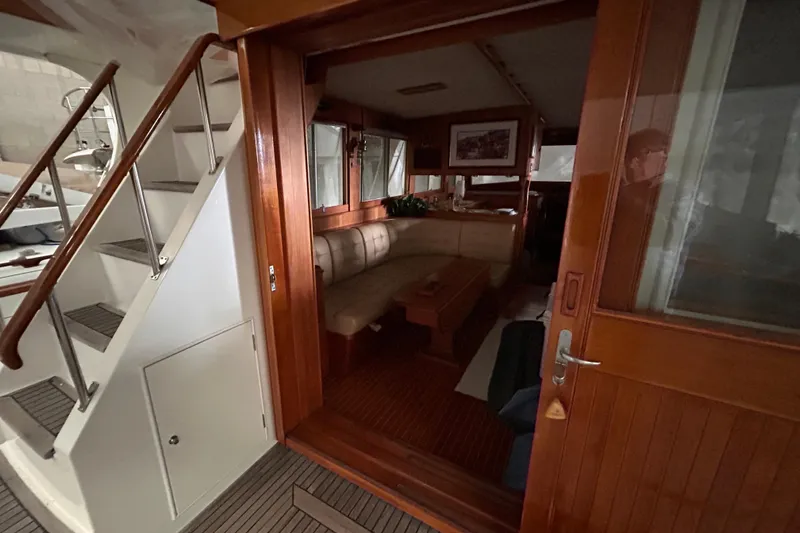 Slide: The Image of Interior view of 1999 Grand Banks 46 Europa yacht, featuring wooden finishes and seating area. - 6