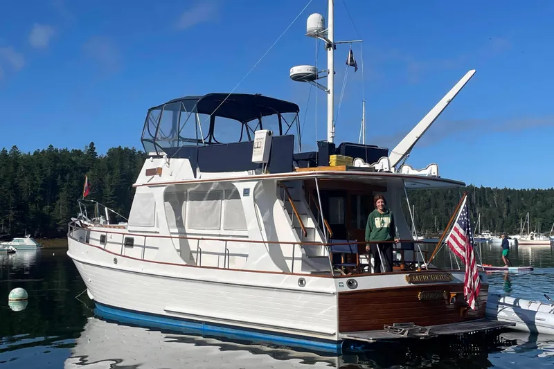 Slide: The Image of Grand Banks 46 Europa yacht, 1999 model, docked with American flag, scenic forest backdrop. - 60