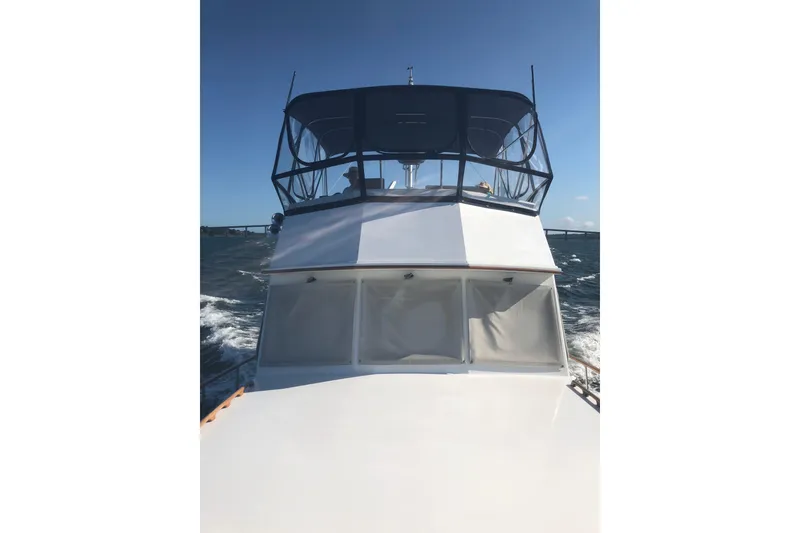 Slide: The Image of 1999 Grand Banks 46 Europa yacht cruising on open water under clear blue skies. - 62