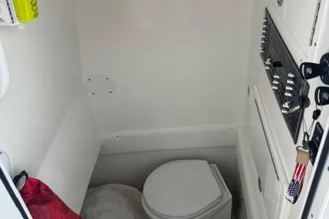 Slide: The Image of 2022 SeaHunter 31 Tournament boat interior with compact marine toilet and storage area. - 6