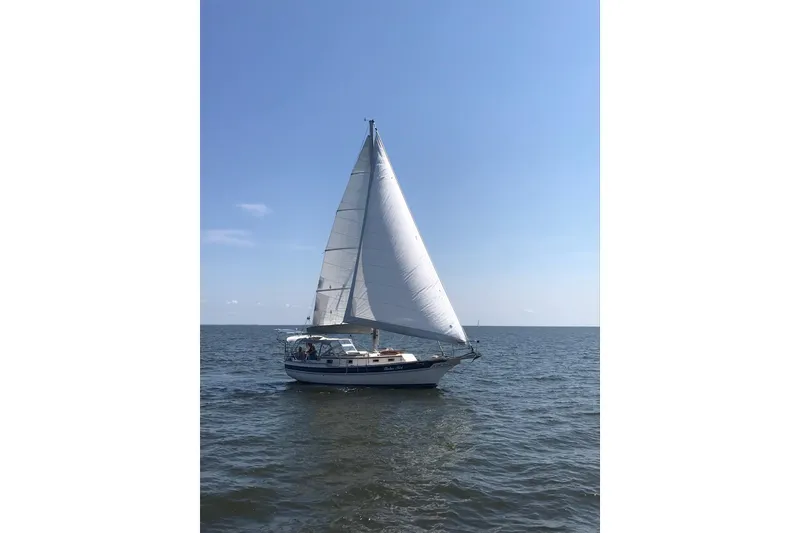 The Image of Sailboat Gozzard 31 from 1990 gliding on open water under clear blue skies. - 0