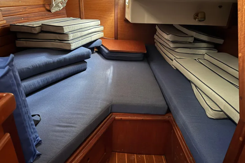 Slide: The Image of Interior cabin of 1990 Gozzard 31 sailboat with blue cushions and wooden finish. - 11