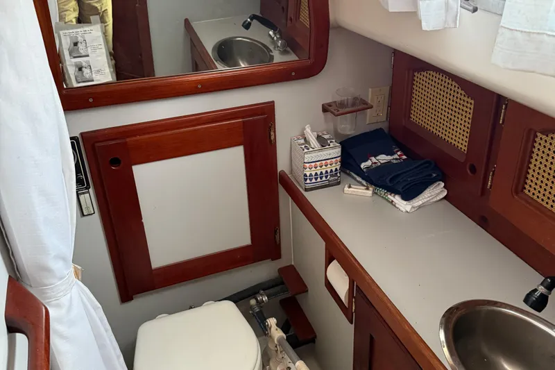Slide: The Image of 1990 Gozzard 31 yacht bathroom with wooden cabinetry, sink, and toilet. - 13