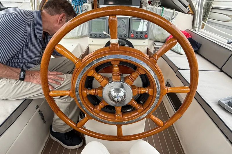 Slide: The Image of Wooden helm of a 1990 Gozzard 31 sailboat with navigational instruments. - 14