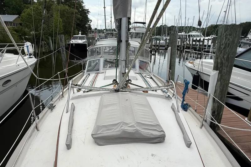 Slide: The Image of Sailboat Gozzard 31, 1990 model, docked at a marina with surrounding boats. - 18