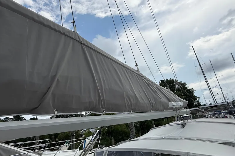 Slide: The Image of Sailboat Gozzard 31, 1990 model, with covered sail against a cloudy sky. - 19