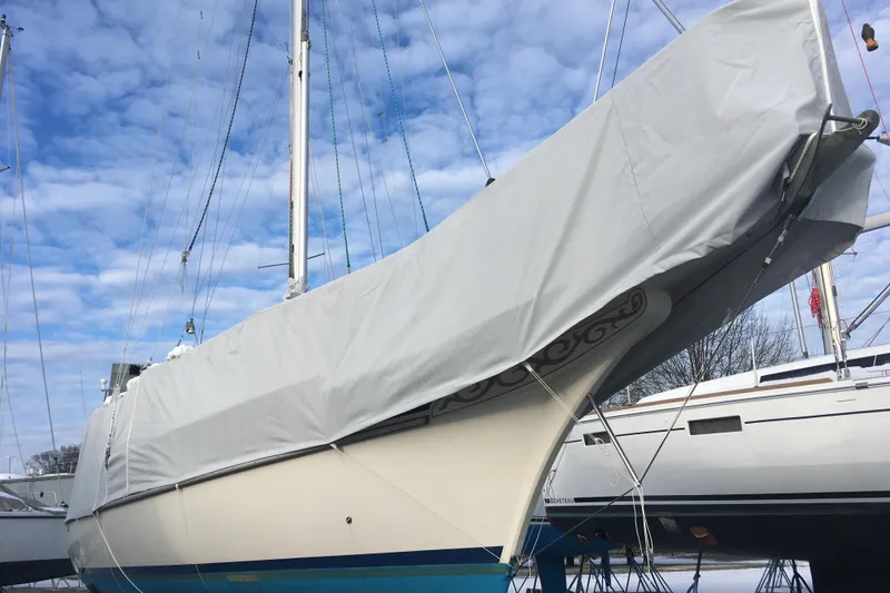 Slide: The Image of 1990 Gozzard 31 sailboat covered, docked under a blue sky. - 20