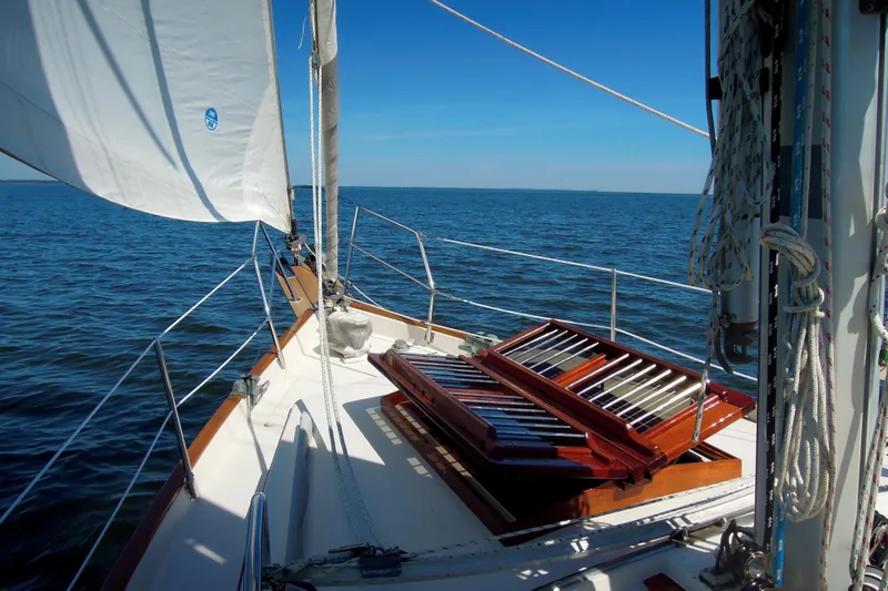 Slide: The Image of Sailing on a 1990 Gozzard 31 yacht with open hatch, blue sea background. - 3