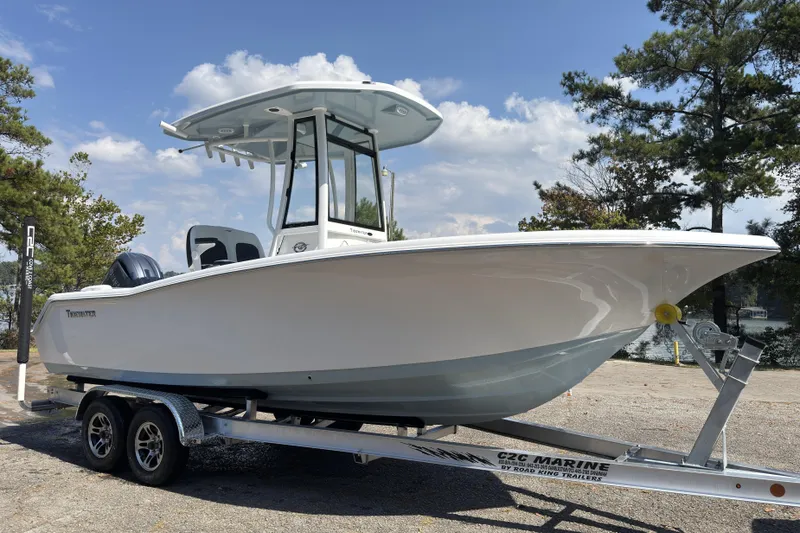 Slide: The Image of 2026 Tidewater 220 LXF boat on trailer, parked outdoors under a clear sky. - 2