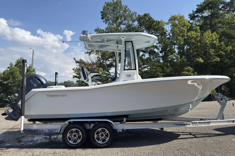 Slide: The Image of 2026 Tidewater 220 LXF boat on trailer, parked outdoors with trees in background. - 3