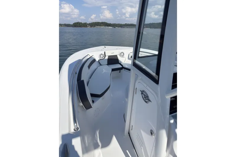 Slide: The Image of 2026 Tidewater 220 LXF boat interior with seating, on a calm lake. - 5