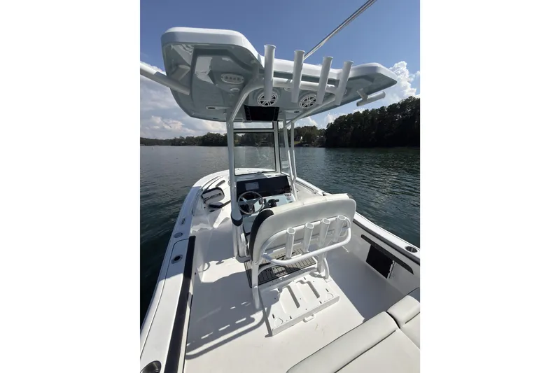 Slide: The Image of 2026 Tidewater 220 LXF boat interior with helm, seating, and rod holders on a calm lake. - 8
