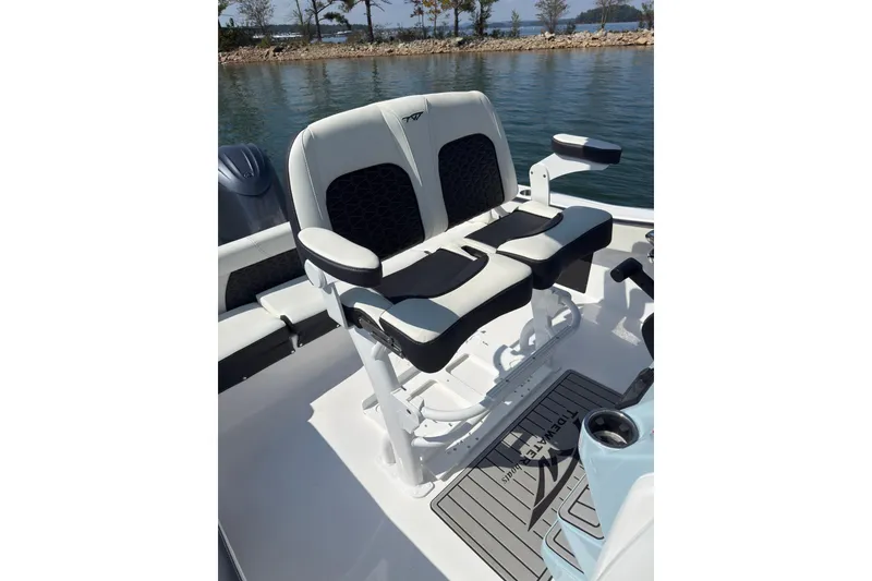 Slide: The Image of 2026 Tidewater 220 LXF boat seating, featuring dual cushioned seats with armrests, on calm water. - 9