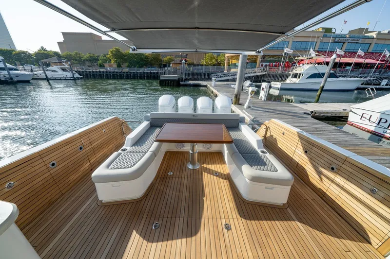 Slide: The Image of 2026 Valhalla V-55 Sport Yacht with elegant deck seating and table, docked at marina. - 8
