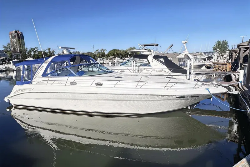The Image of 2000 Sea Ray 410 Sundancer yacht docked in a marina under clear blue skies. - 0