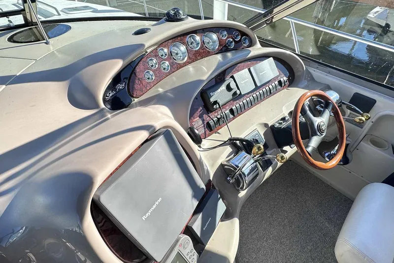 Slide: The Image of Control panel of a 2000 Sea Ray 410 Sundancer boat with steering wheel and gauges. - 14