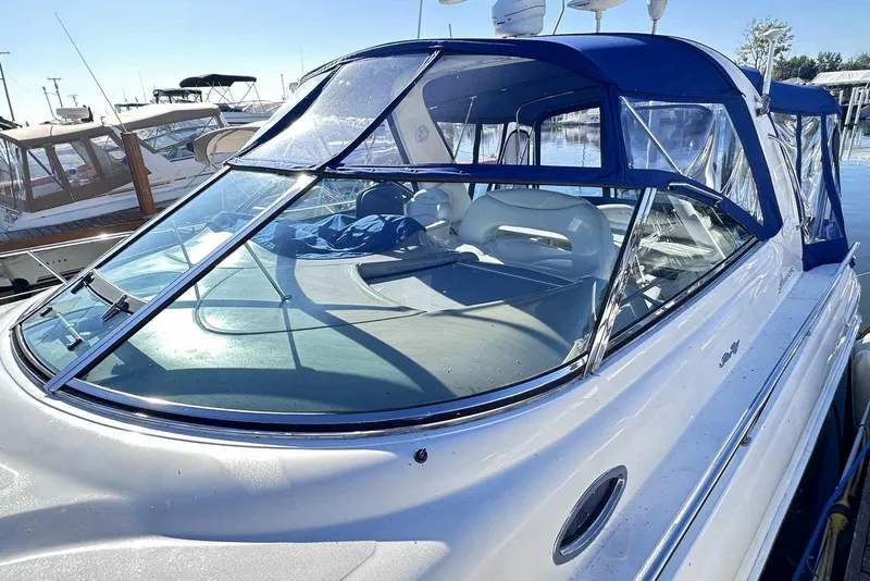 Slide: The Image of 2000 Sea Ray 410 Sundancer yacht with blue canopy docked at marina. - 2