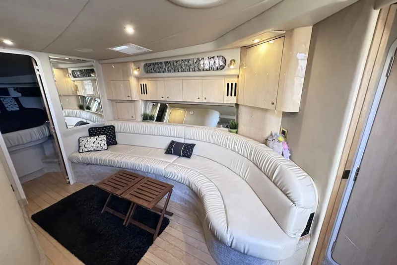 Slide: The Image of Luxurious interior of 2000 Sea Ray 410 Sundancer yacht with curved seating and elegant decor. - 20
