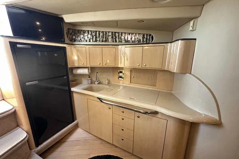 Slide: The Image of Interior of 2000 Sea Ray 410 Sundancer yacht with kitchenette and modern amenities. - 22