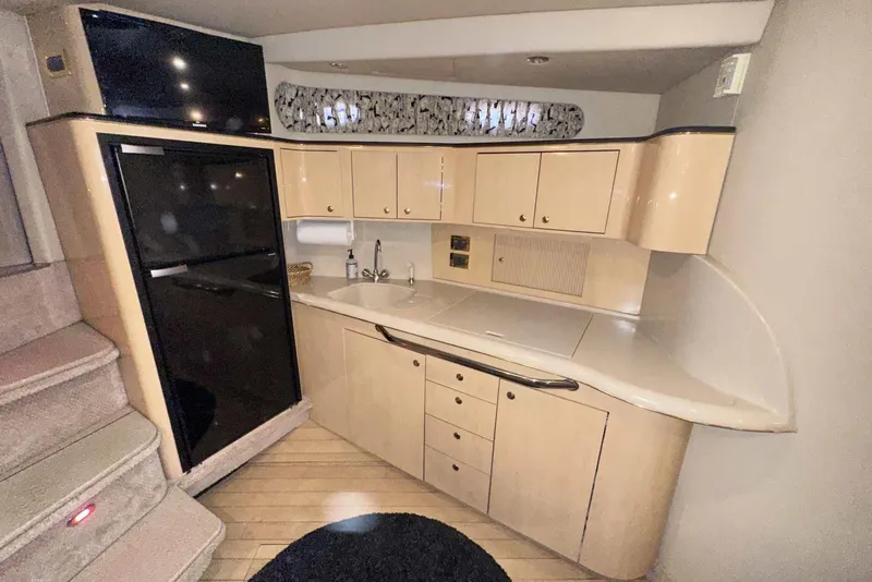 Slide: The Image of 2000 Sea Ray 410 Sundancer yacht interior kitchen with cabinets and sink. - 23