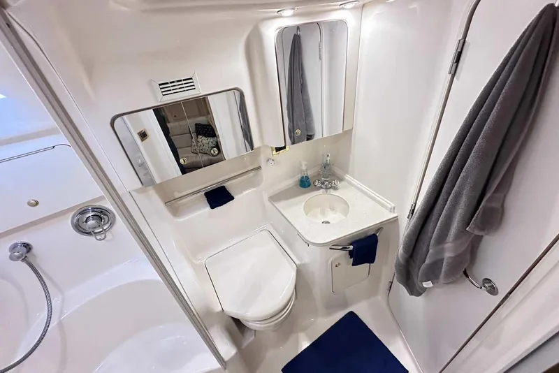 Slide: The Image of Bathroom interior of 2000 Sea Ray 410 Sundancer yacht, featuring sink, toilet, and mirror. - 35