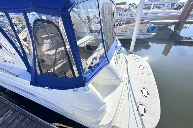 Slide: The Image of 2000 Sea Ray 410 Sundancer docked, featuring blue canopy and spacious deck. - 4