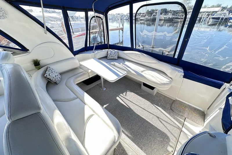 Slide: The Image of Interior of 2000 Sea Ray 410 Sundancer yacht with white seating and marina view. - 6