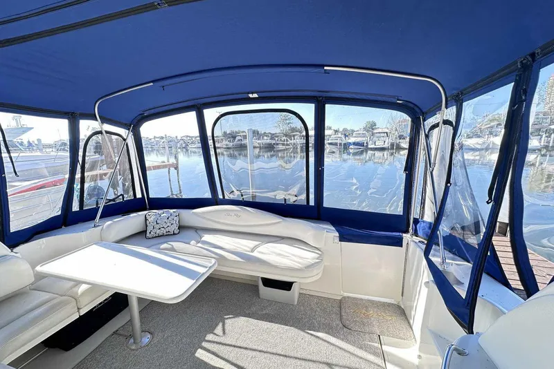 Slide: The Image of Interior view of 2000 Sea Ray 410 Sundancer with blue canopy and marina backdrop. - 7