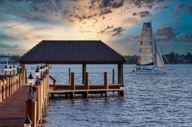 The Image of Sailboat Corsair Cruze 970 #396 near a wooden dock at sunset, 2017. - 0