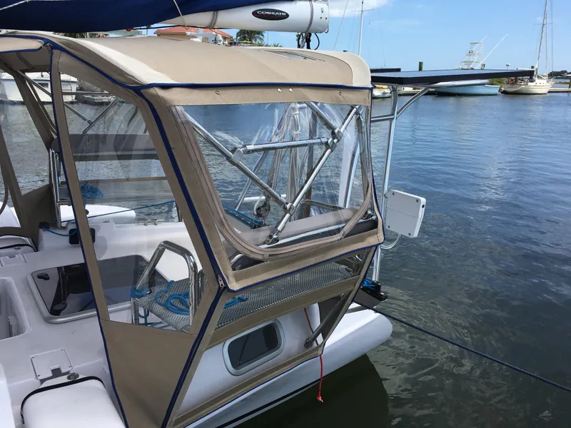 Slide: The Image of 2017 Corsair Cruze 970 sailboat docked, featuring a beige canopy and clear windows. - 14