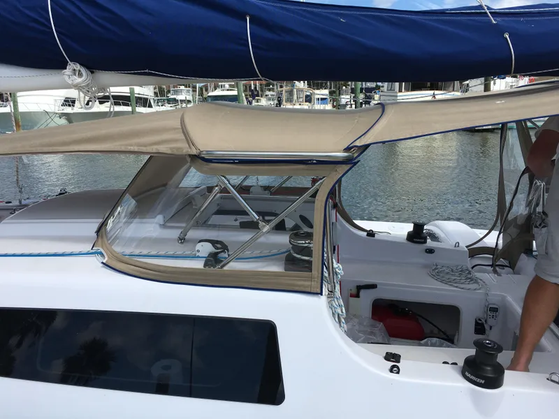 Slide: The Image of 2017 Corsair Cruze 970 sailboat with beige canopy and blue sail, docked at marina. - 19