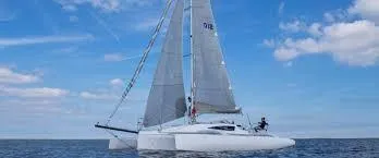 Slide: The Image of 2017 Corsair Cruze 970 #396 sailing on open water under a clear blue sky. - 2