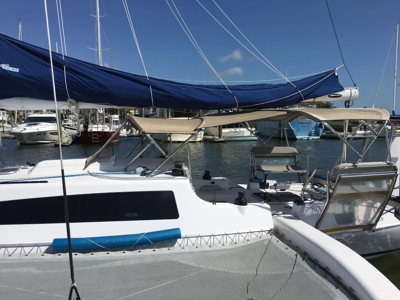 Slide: The Image of 2017 Corsair Cruze 970 #396 sailboat docked in marina, featuring blue and beige canopies. - 20