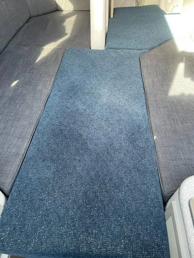 Slide: The Image of Interior seating of 2017 Corsair Cruze 970 sailboat with blue cushions. - 24