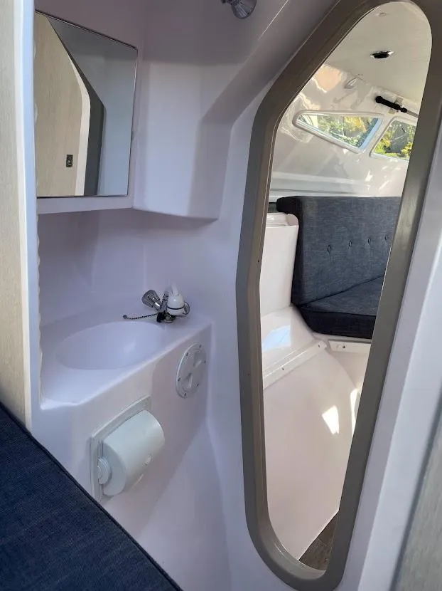 Slide: The Image of Interior of 2017 Corsair Cruze 970 #396 sailboat, featuring compact bathroom and seating area. - 26