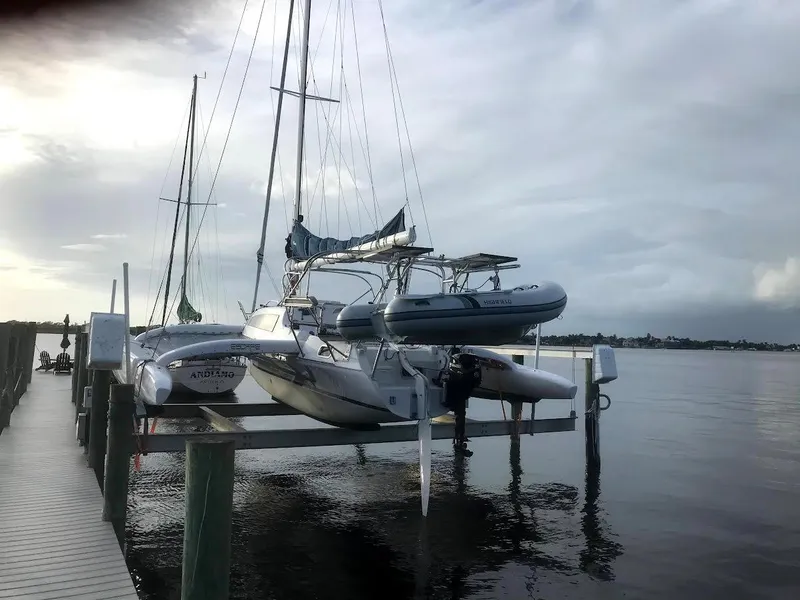 Slide: The Image of 2017 Corsair Cruze 970 #396 trimaran docked on calm waters at sunset. - 5