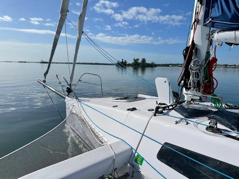 Slide: The Image of 2017 Corsair Cruze 970 sailboat on calm water under a clear blue sky. - 6