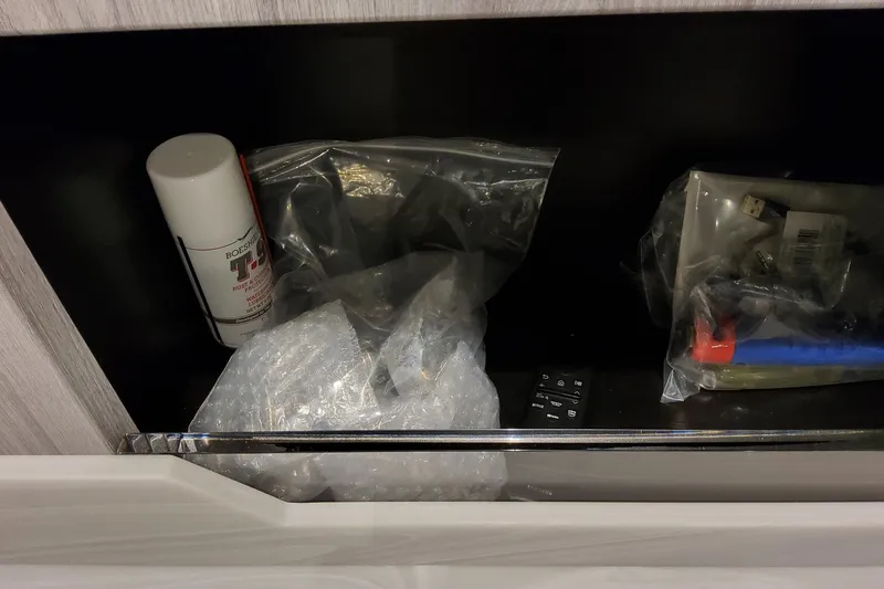 Slide: The Image of Storage compartment with spray can, bubble wrap, and miscellaneous items in a Formula 400 Super Sport Crossover. - 117