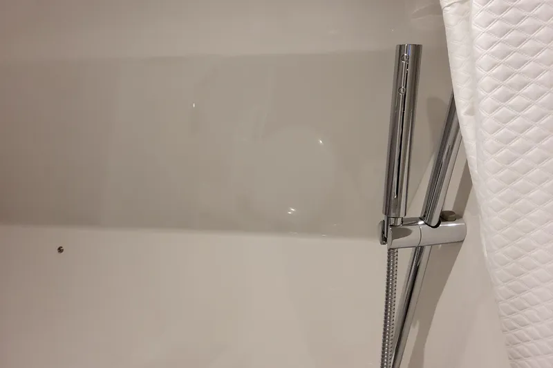 Slide: The Image of Modern bathroom shower with chrome fixtures and white quilted curtain. - 131